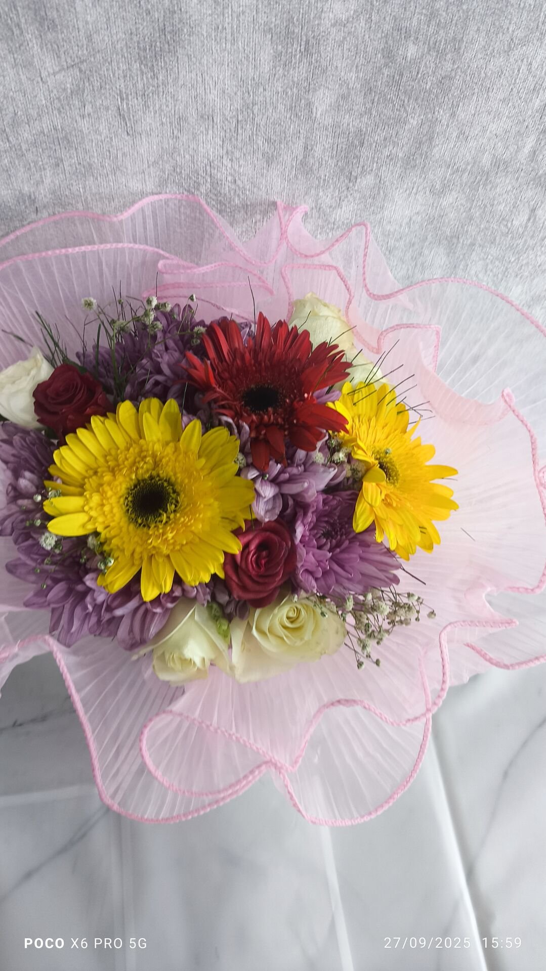 Yeşil Plastik Vazoda Karışık Renkli Çiçekler