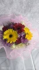 Yeşil Plastik Vazoda Karışık Renkli Çiçekler